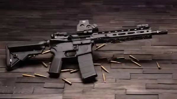 A rifle sitting on top of a wooden floor.