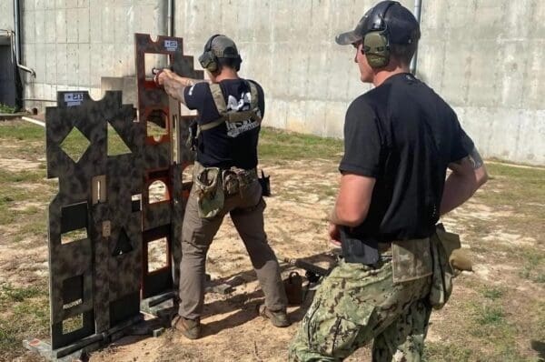 Two men are practicing shooting at a target.