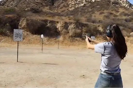 A man is shooting at a target with his gun.