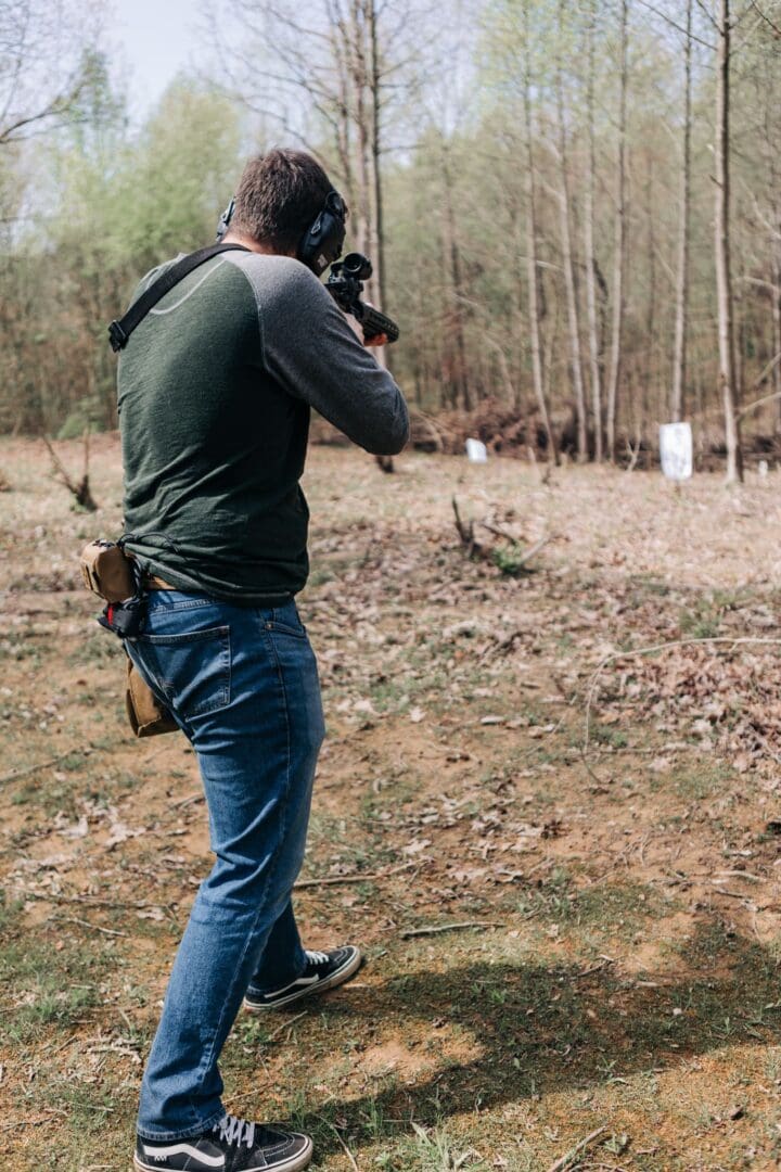 A man holding a gun in the woods