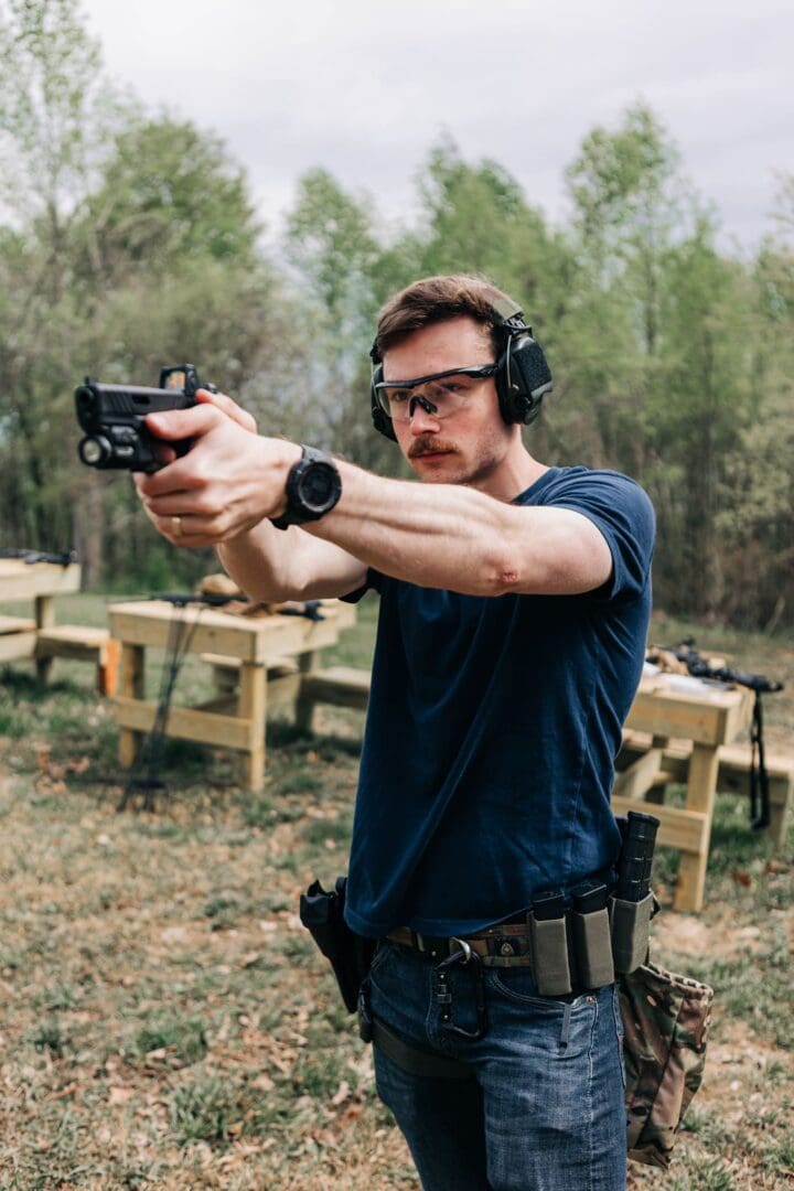 A man holding a gun while wearing headphones.