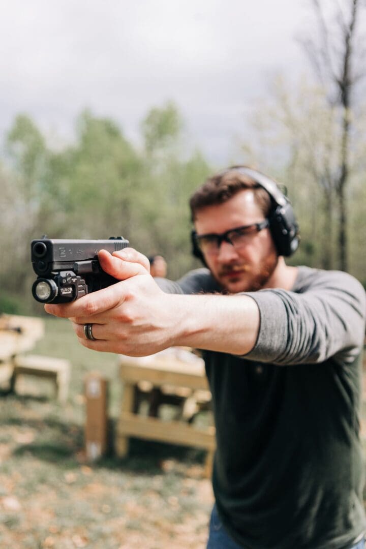 A man wearing headphones and holding a gun.