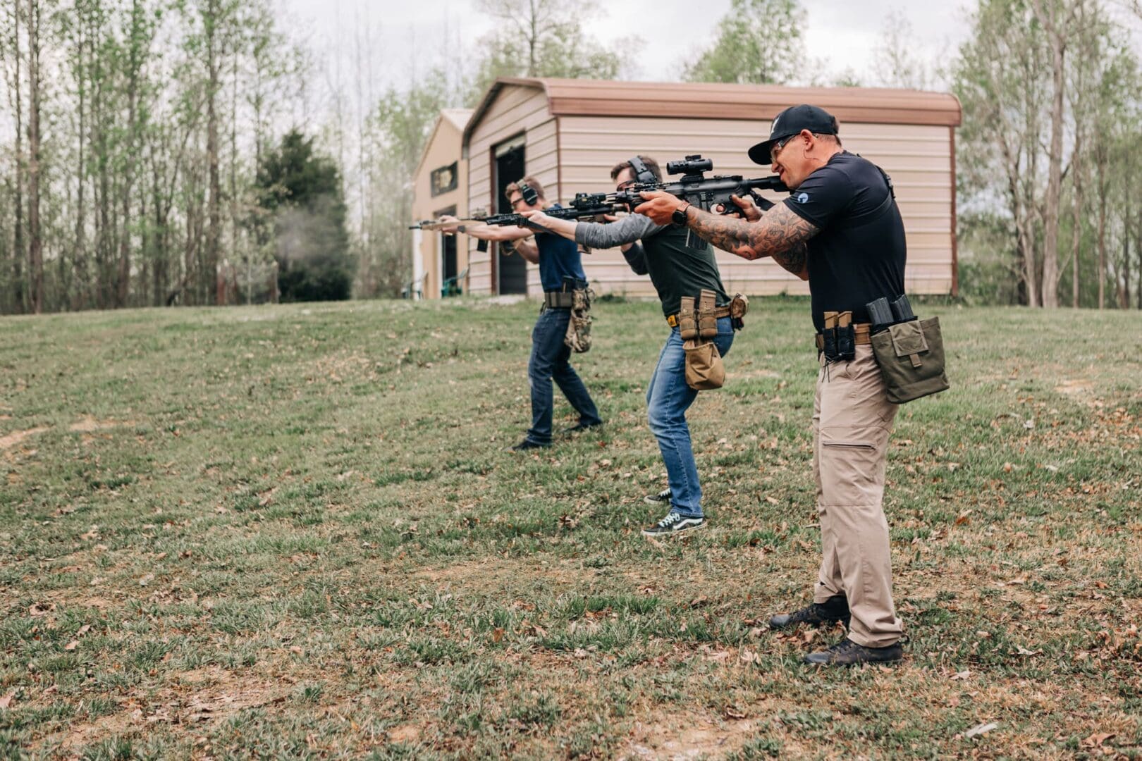 A group of men holding guns in the grass.