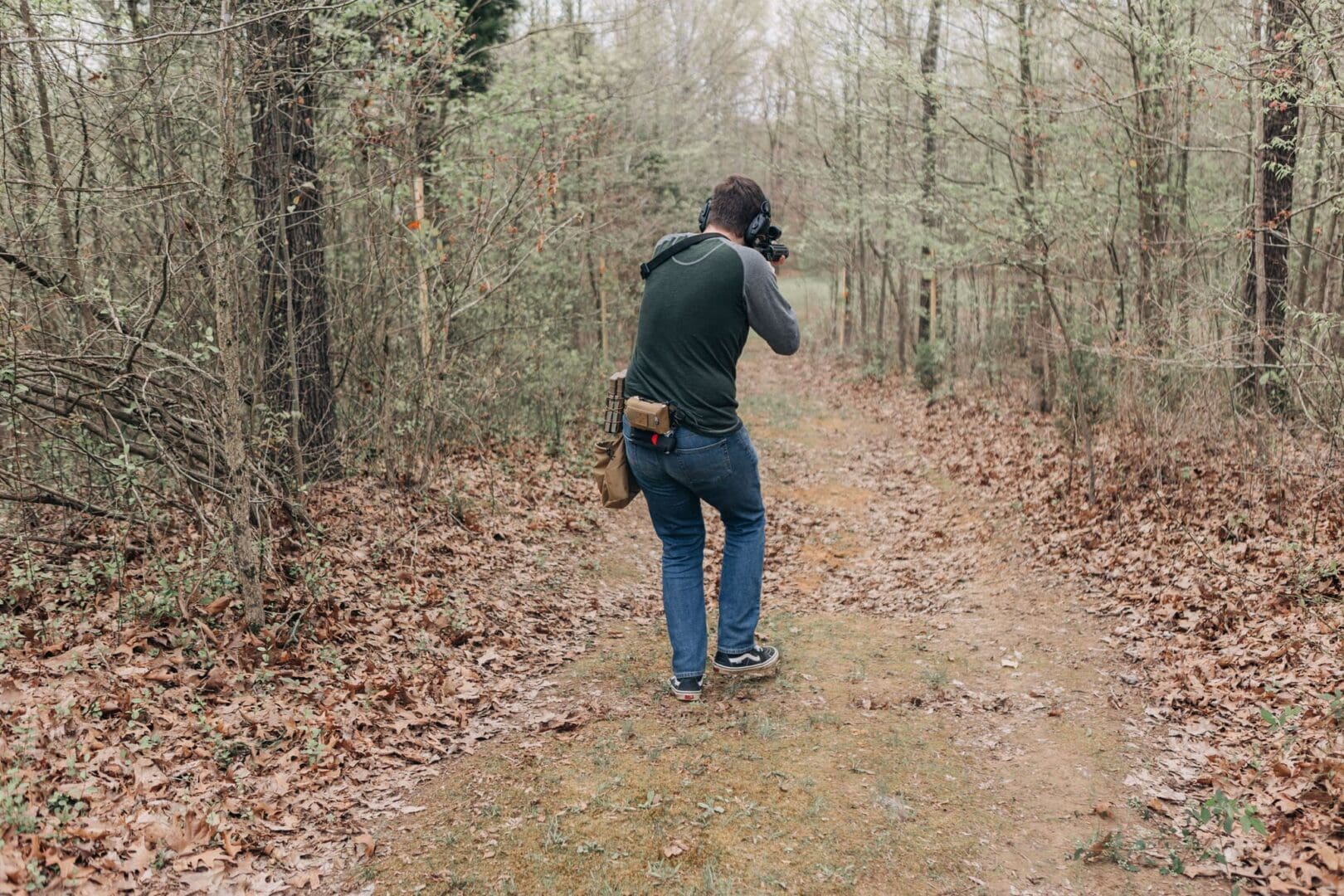 A man is taking pictures in the woods