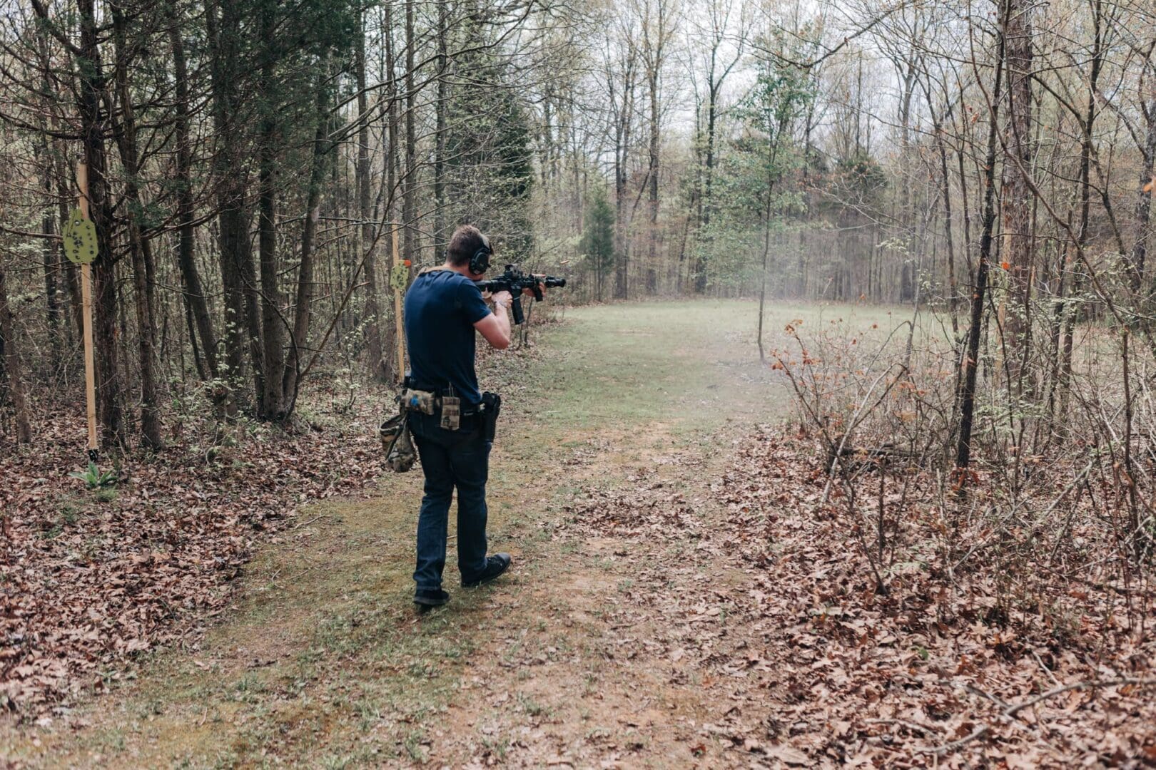 A man holding an ar-1 5 rifle in the woods.