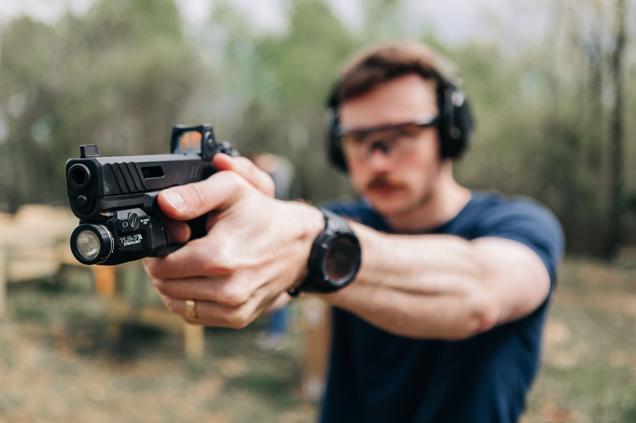 A man wearing headphones and holding a gun.