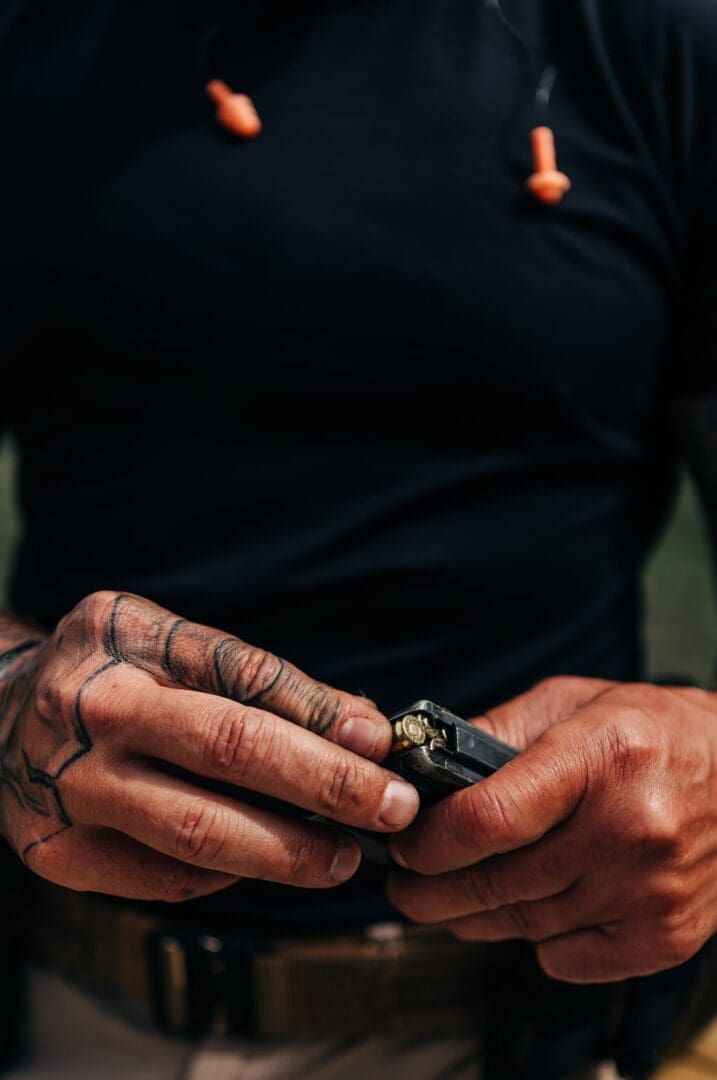 A person with tattoos on their hands holding a cell phone.