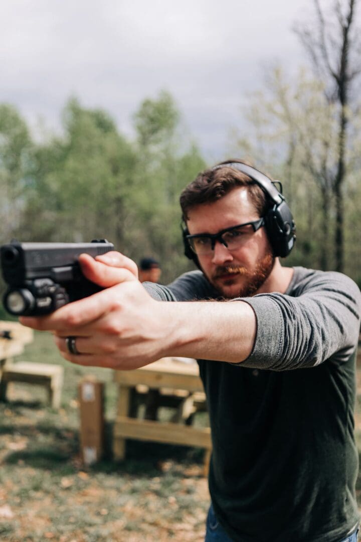 A man wearing headphones and holding a gun.