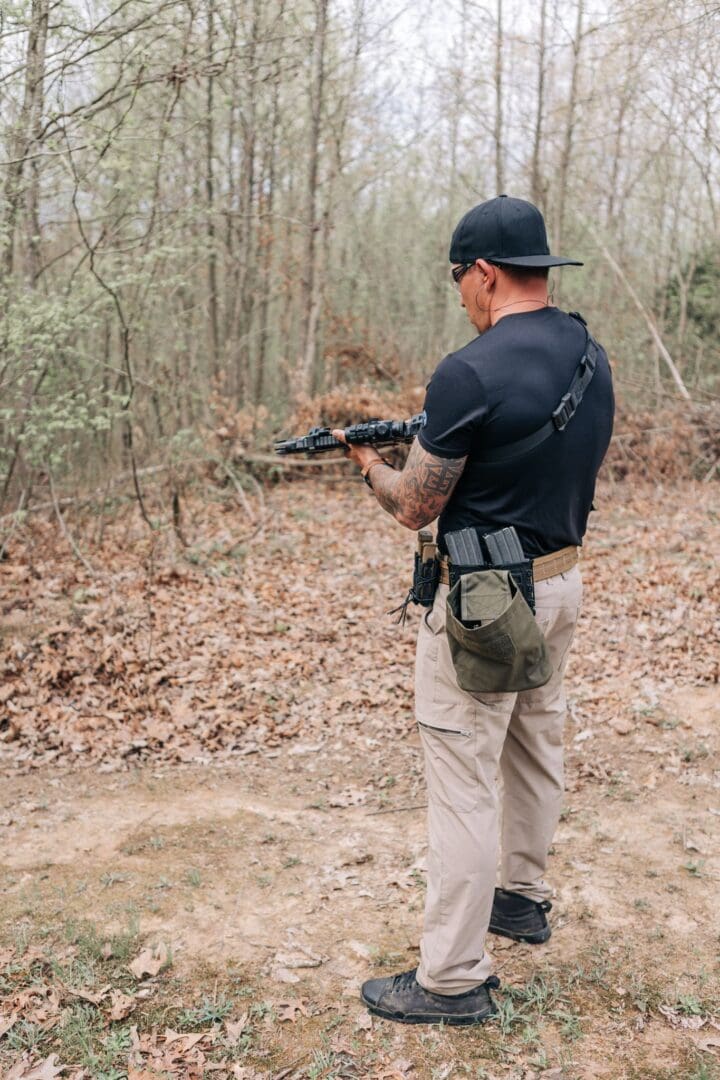 A man holding an ar-1 5 rifle in the woods.