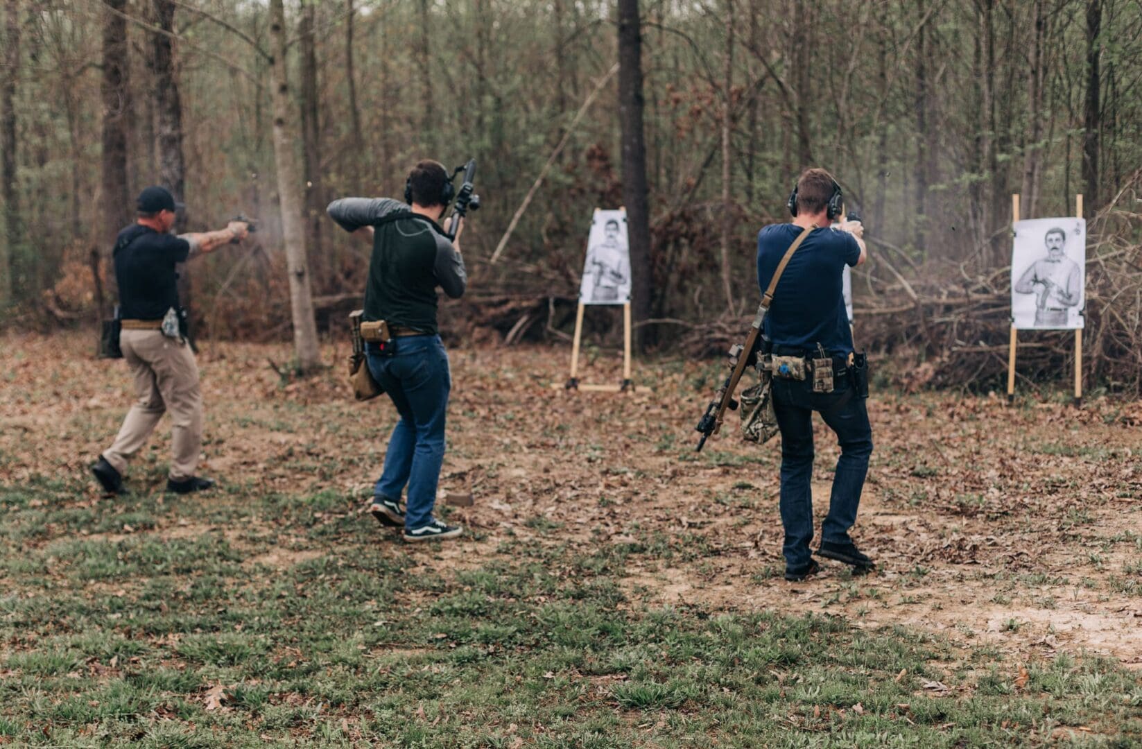 Two people are shooting at a target in the woods.