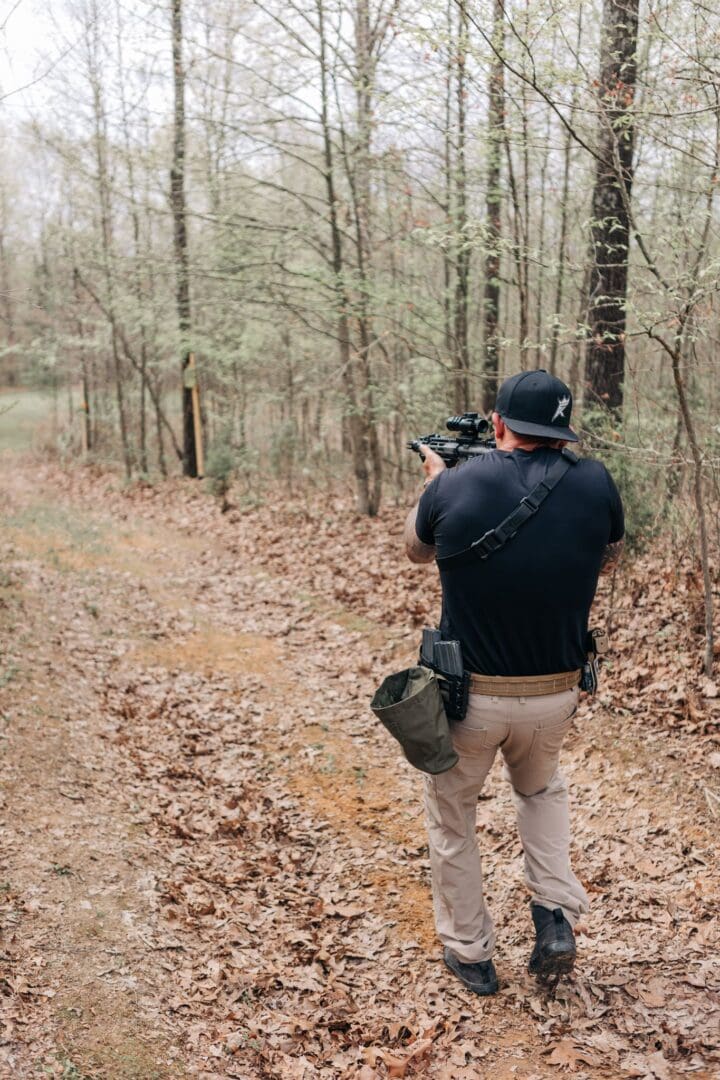 A man in the woods taking pictures with his camera.