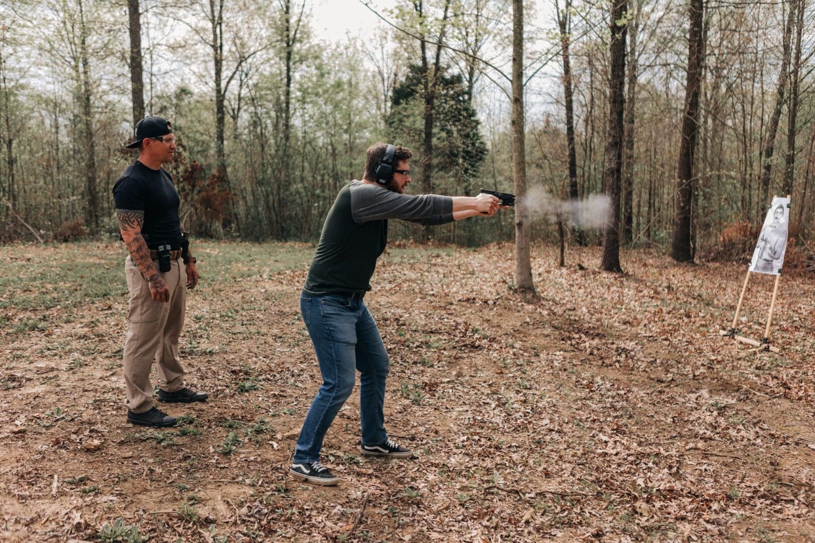 A man is shooting an object in the woods