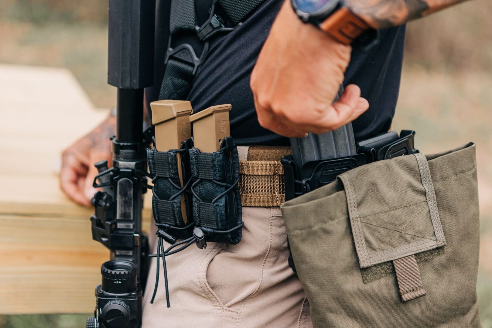 A man holding an ar-1 5 and wearing a gun holster.