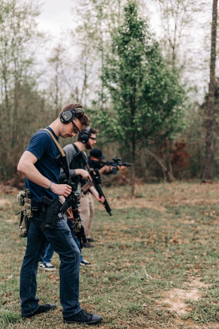 A group of people with guns in the woods.