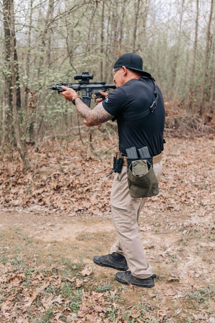 A man holding an ar-1 5 rifle in the woods.