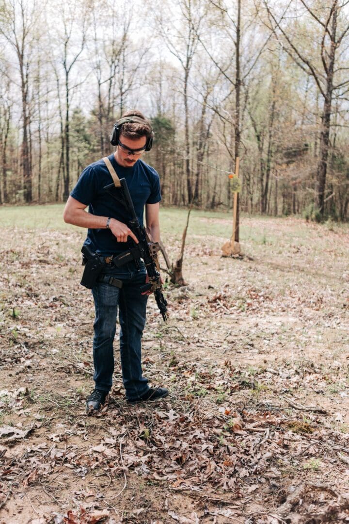 A man holding an ar-1 5 rifle in the woods.