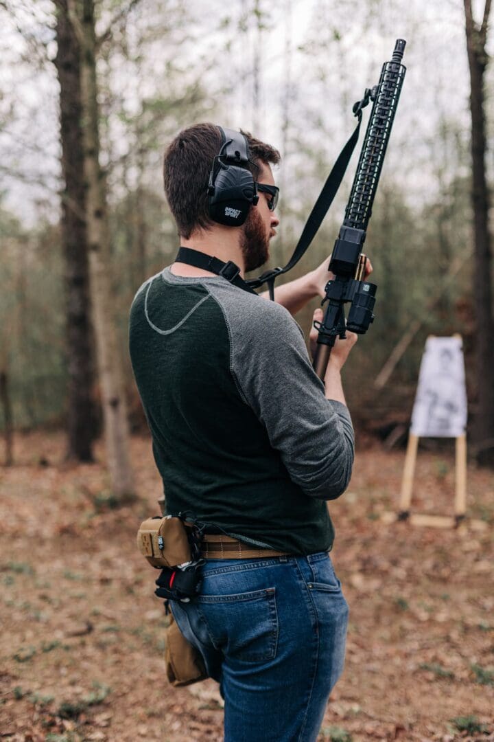 A man holding a rifle in the woods