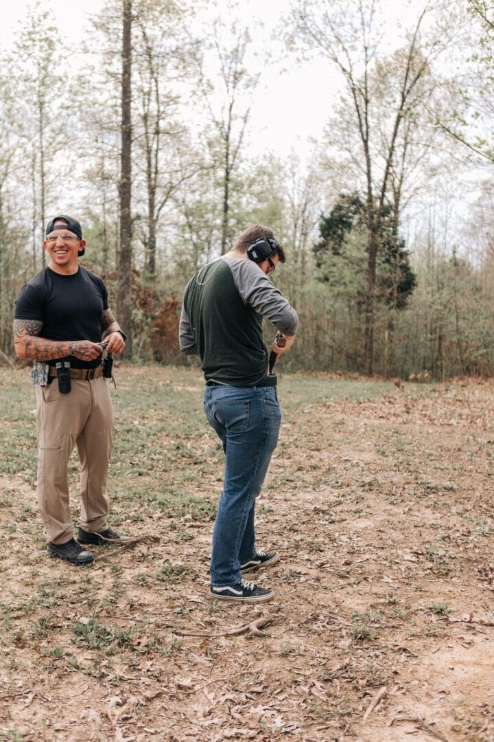 Two men standing in a field with guns