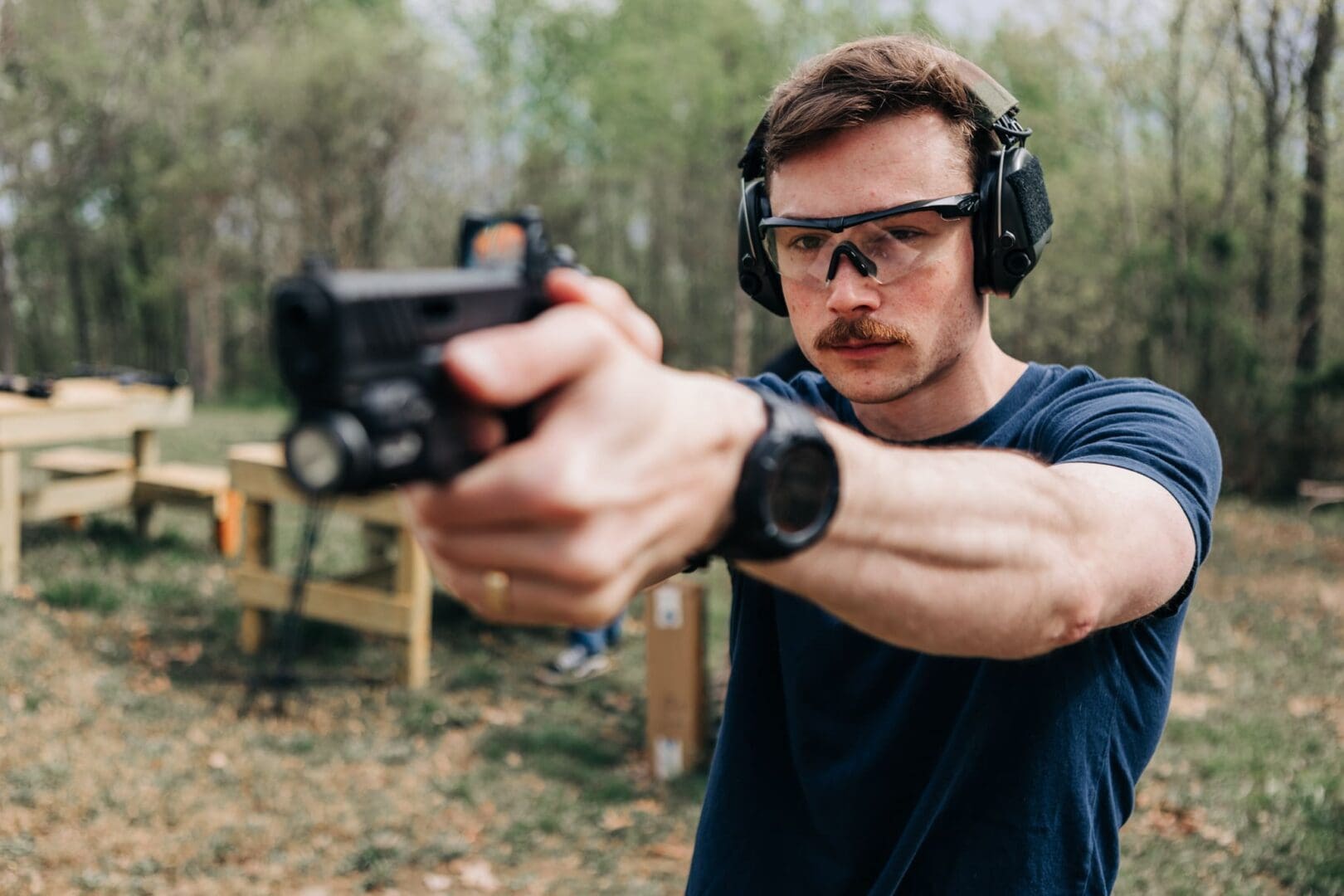 A man wearing headphones and holding a gun.