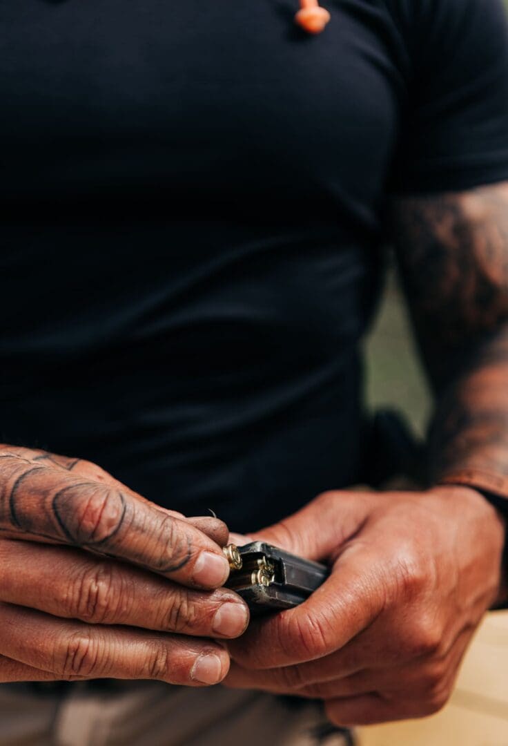 A person with tattoos holding something in their hands.