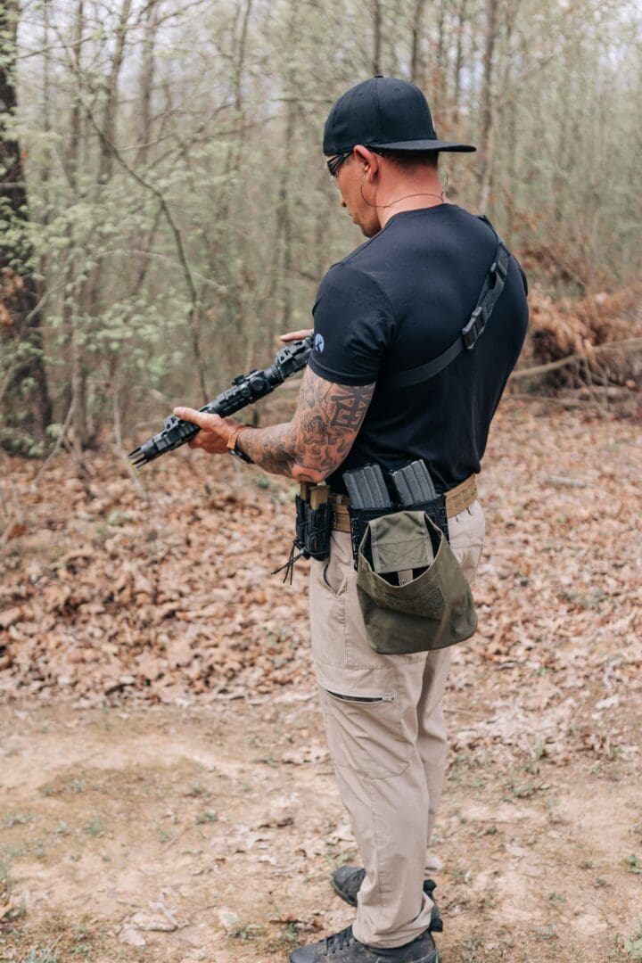 A man holding a gun in the woods