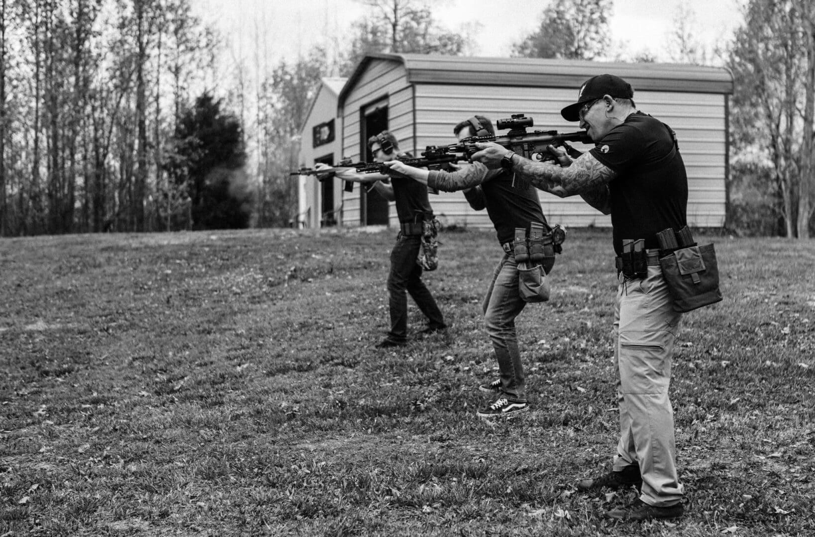 A group of men holding guns in the grass.