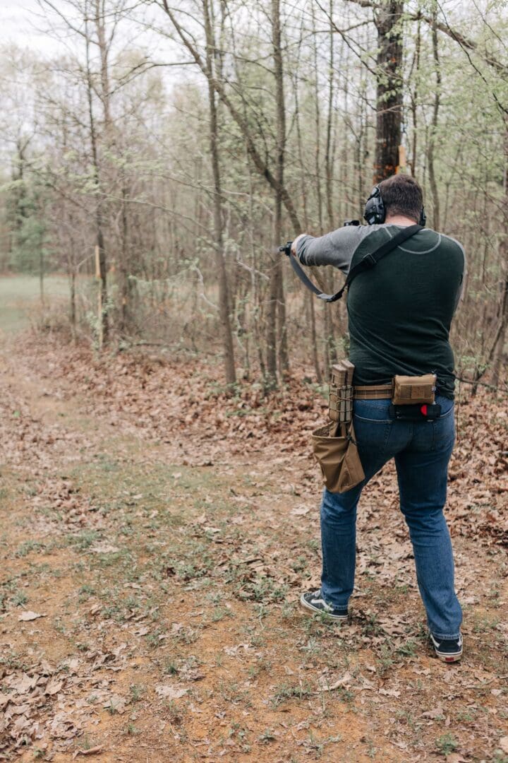 A man is shooting an animal in the woods.