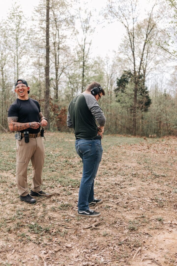 Two men standing in a field with guns