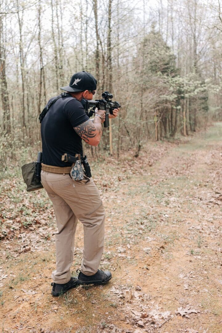 A man in the woods taking pictures with his camera.