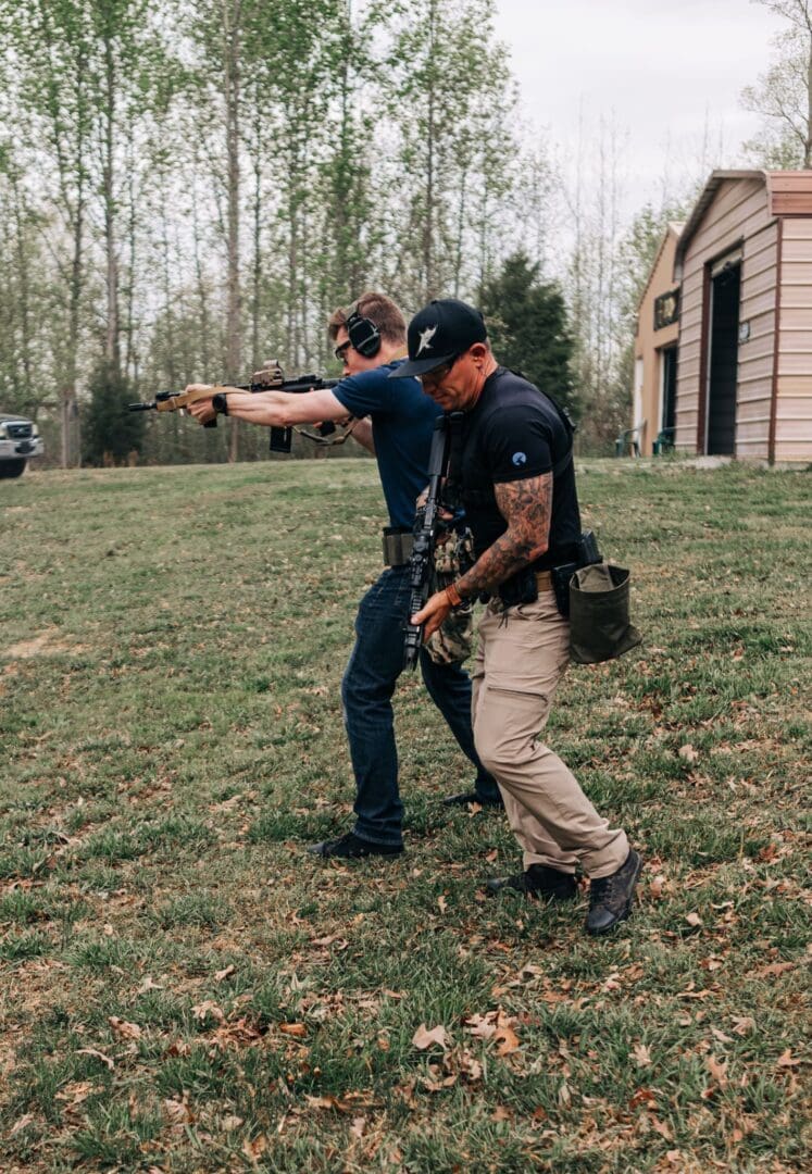 Two men in black shirts and blue pants pointing