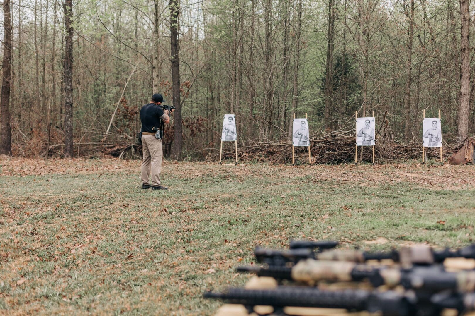 A man is shooting at targets in the woods.