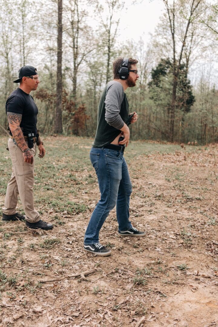 Two men standing in a field with guns