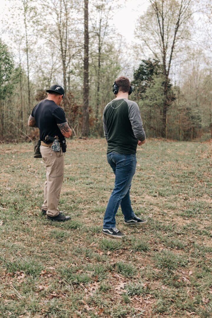 Two men standing in a field with guns