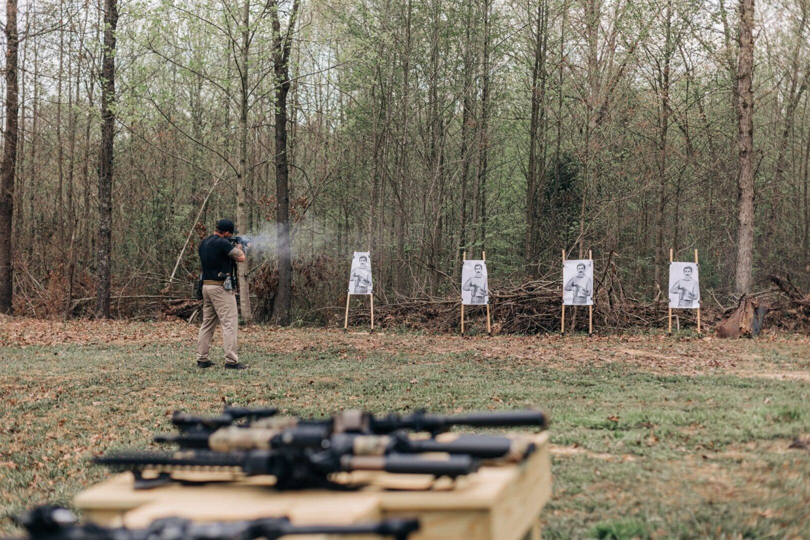 A man is shooting at targets in the woods.