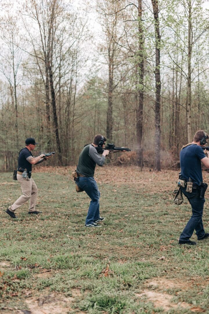 A group of men are practicing shooting at trees.