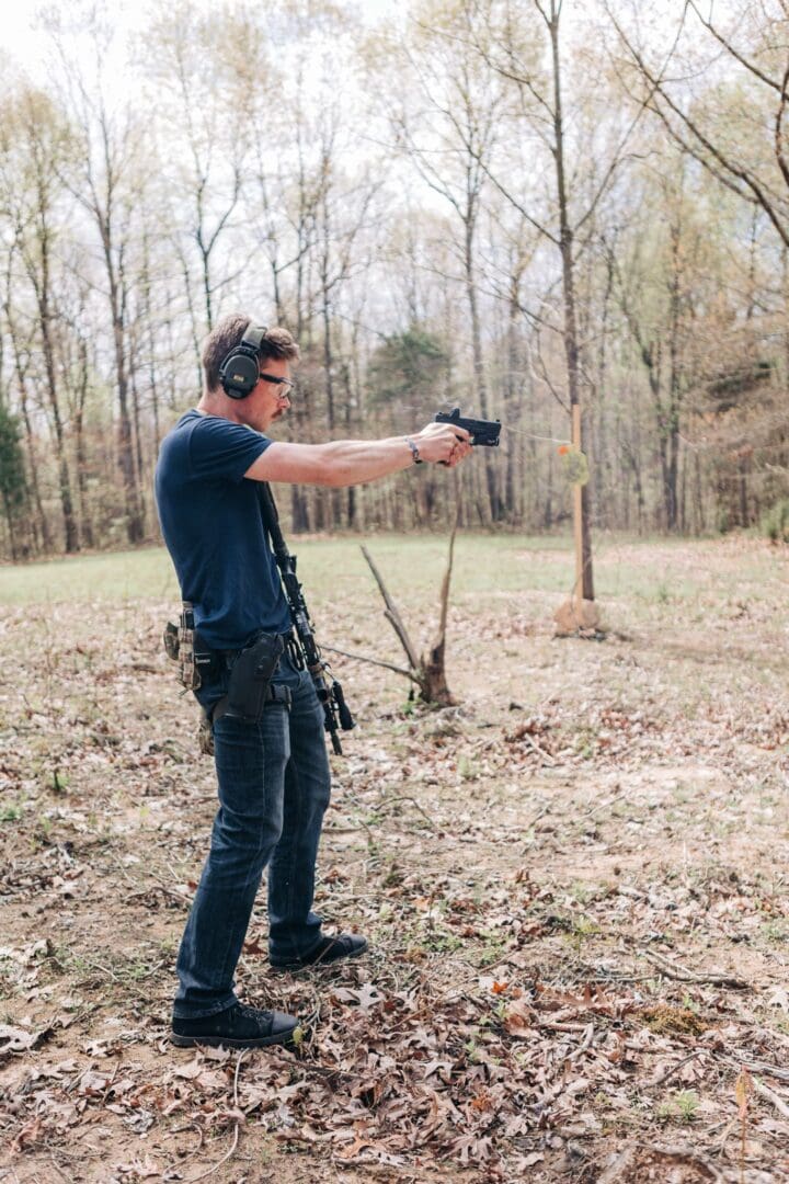 A man in the woods holding a gun