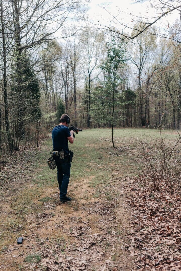 A man in the woods with a rifle.