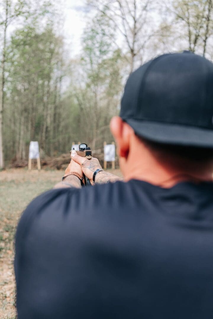 A man is holding his gun at the range