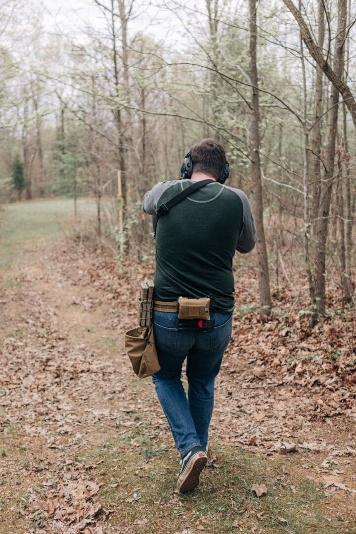 A man walking through the woods with his camera.