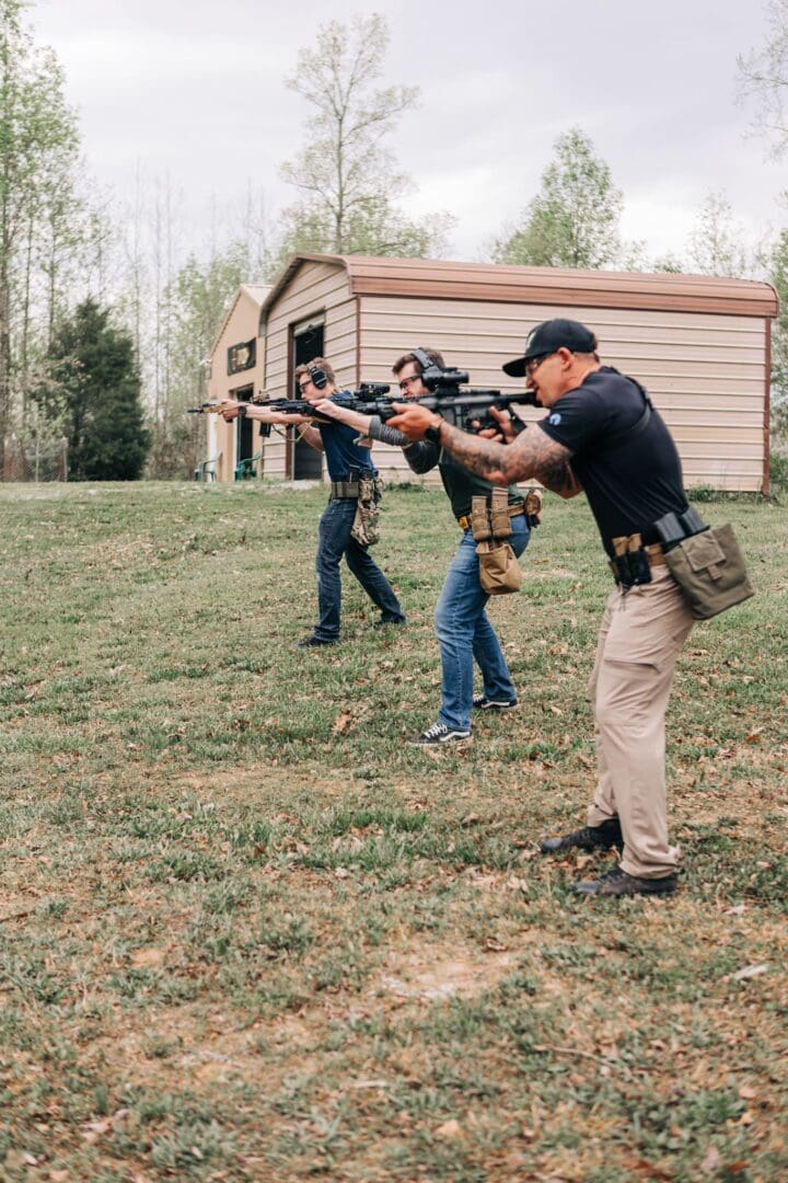 A group of people with guns in the grass.