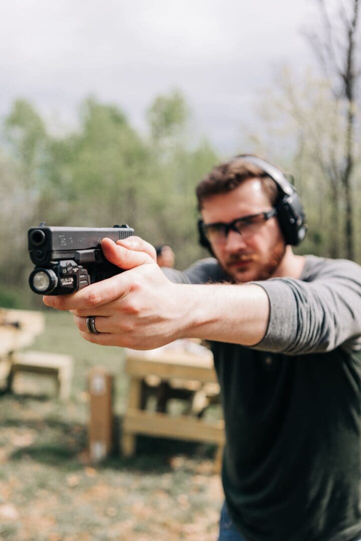 A man wearing headphones and holding a gun.