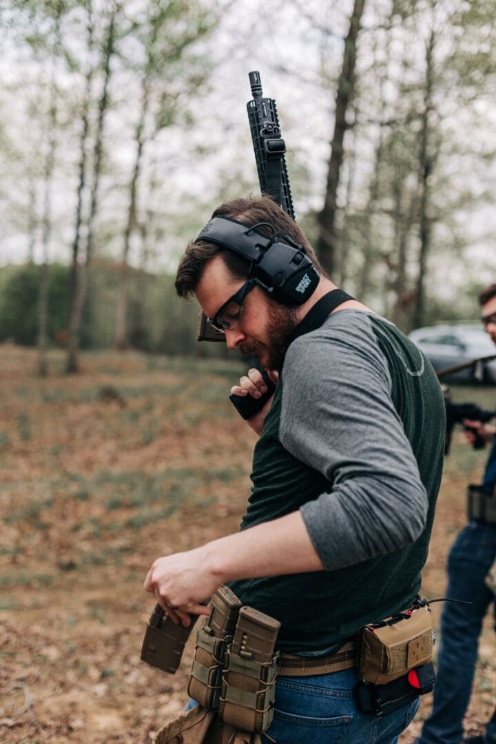 A man with headphones on holding a gun.