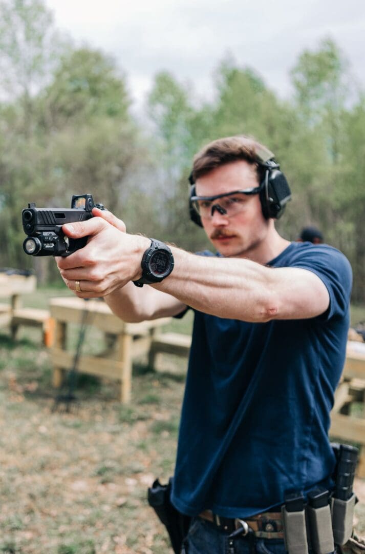 A man wearing headphones and holding a gun.